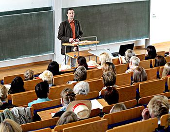 Dozent der Sexualpädagogik referiert während einer Fachtagung im Hörsaal vor einem großen Publikum