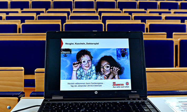 Eine offene Internetseite auf dem Laptop am Rednerpult in einem Hörsaal.